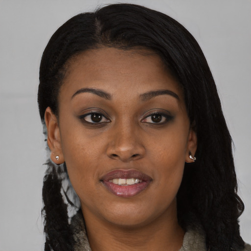 Joyful black young-adult female with long  black hair and brown eyes