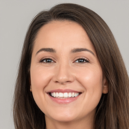 Joyful white young-adult female with long  brown hair and brown eyes