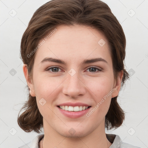 Joyful white young-adult female with medium  brown hair and grey eyes