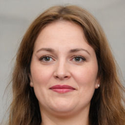 Joyful white adult female with long  brown hair and brown eyes