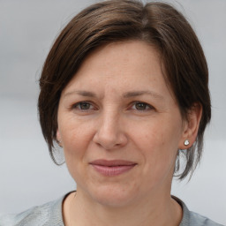 Joyful white adult female with medium  brown hair and grey eyes