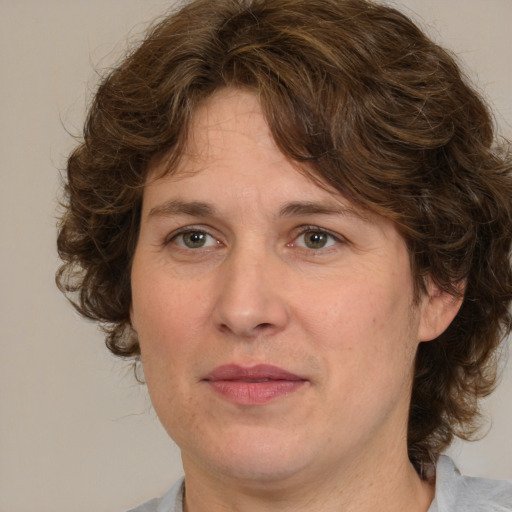 Joyful white adult female with medium  brown hair and green eyes