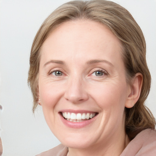 Joyful white adult female with medium  brown hair and blue eyes