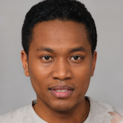 Joyful black young-adult male with short  black hair and brown eyes