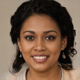 Joyful black young-adult female with long  brown hair and brown eyes