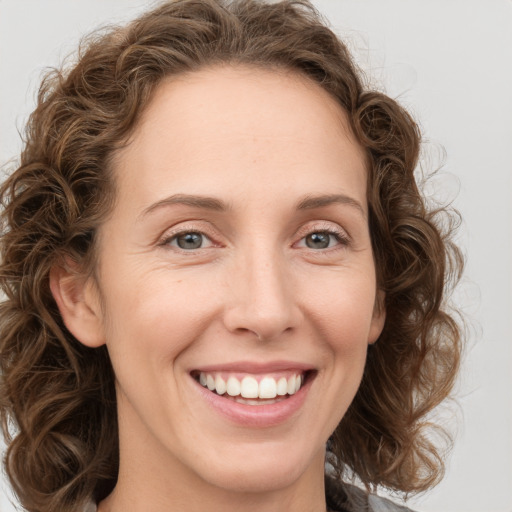 Joyful white young-adult female with medium  brown hair and green eyes