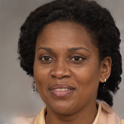 Joyful black adult female with short  brown hair and brown eyes