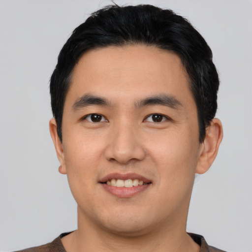 Joyful asian young-adult male with short  black hair and brown eyes