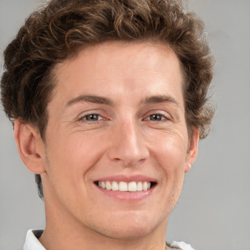 Joyful white adult male with short  brown hair and grey eyes