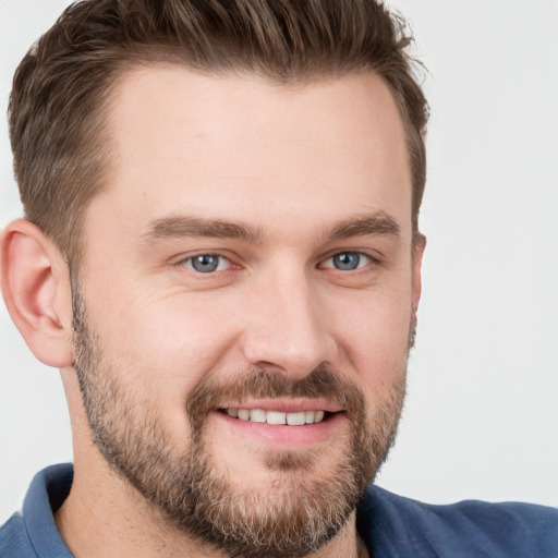 Joyful white young-adult male with short  brown hair and grey eyes