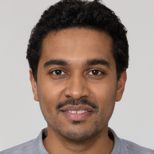 Joyful black young-adult male with short  black hair and brown eyes