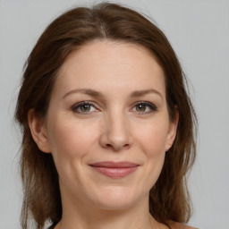 Joyful white adult female with medium  brown hair and grey eyes