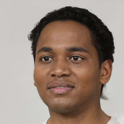 Joyful black young-adult male with short  black hair and brown eyes