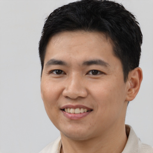 Joyful latino young-adult male with short  black hair and brown eyes