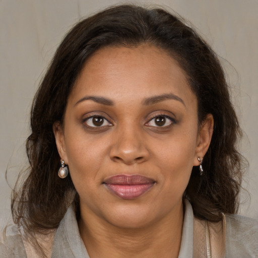 Joyful latino young-adult female with medium  brown hair and brown eyes