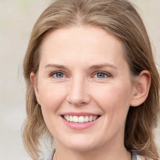 Joyful white young-adult female with medium  brown hair and blue eyes