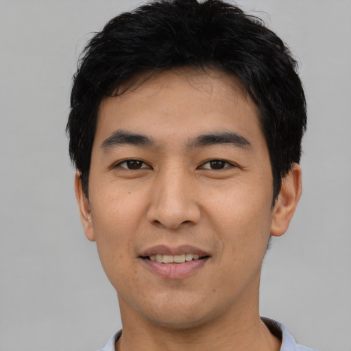 Joyful asian young-adult male with short  black hair and brown eyes