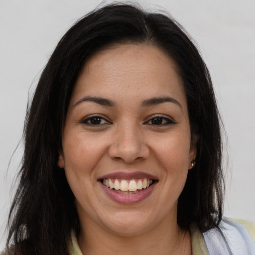 Joyful latino young-adult female with long  brown hair and brown eyes