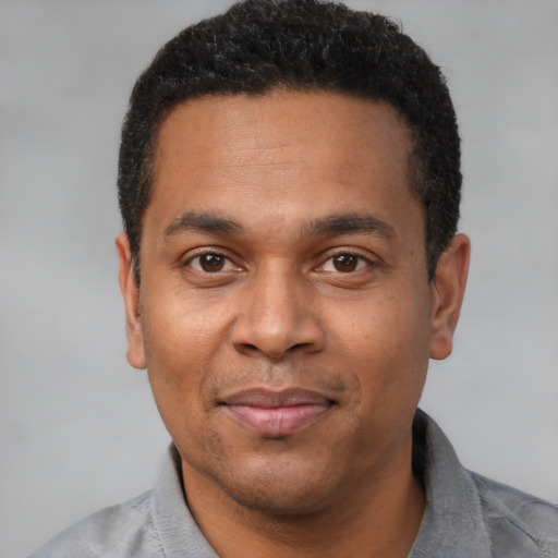 Joyful latino adult male with short  black hair and brown eyes