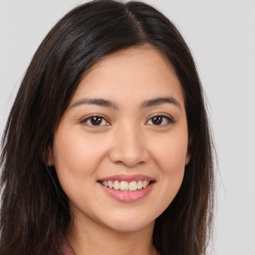 Joyful white young-adult female with long  brown hair and brown eyes