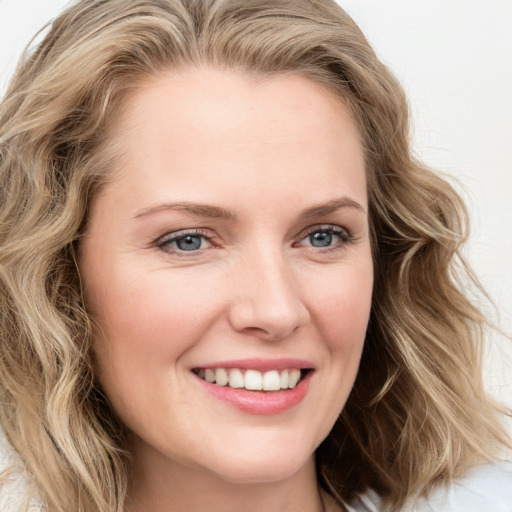 Joyful white young-adult female with long  brown hair and blue eyes