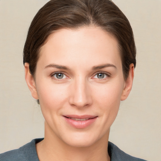 Joyful white young-adult female with short  brown hair and grey eyes