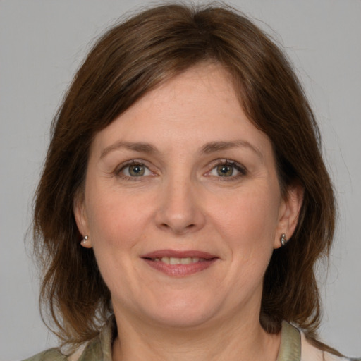 Joyful white adult female with medium  brown hair and grey eyes