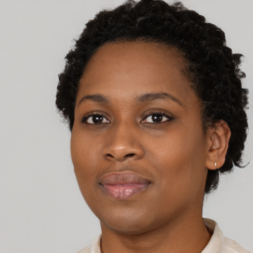 Joyful black young-adult female with short  black hair and brown eyes
