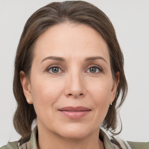 Joyful white adult female with medium  brown hair and grey eyes