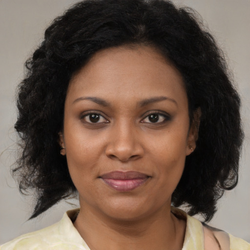 Joyful black adult female with medium  brown hair and brown eyes