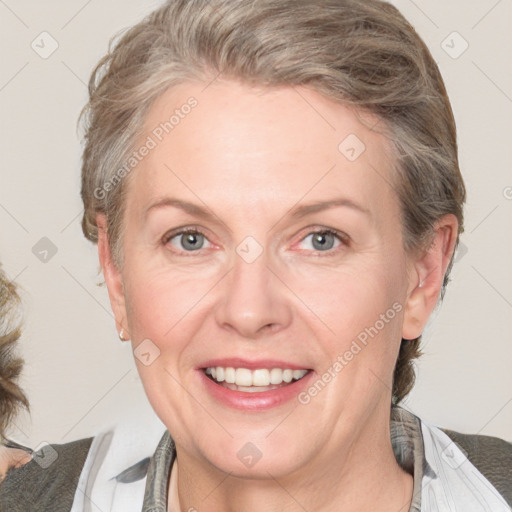 Joyful white adult female with medium  brown hair and blue eyes