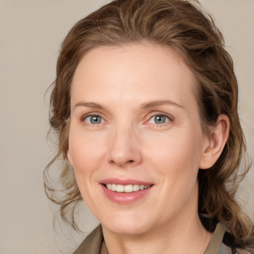 Joyful white young-adult female with medium  brown hair and blue eyes