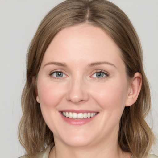 Joyful white young-adult female with medium  brown hair and green eyes