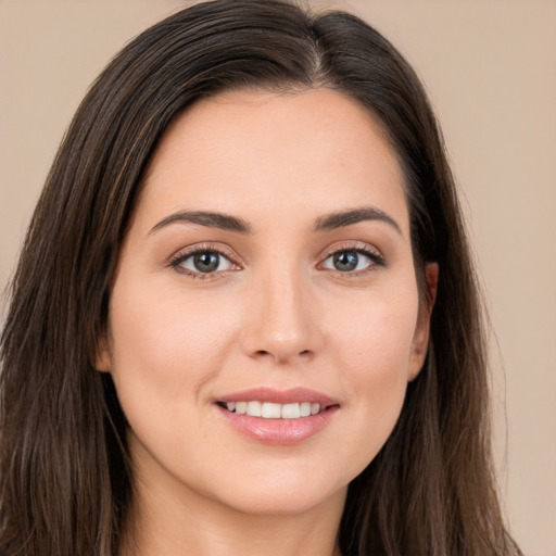 Joyful white young-adult female with long  brown hair and brown eyes