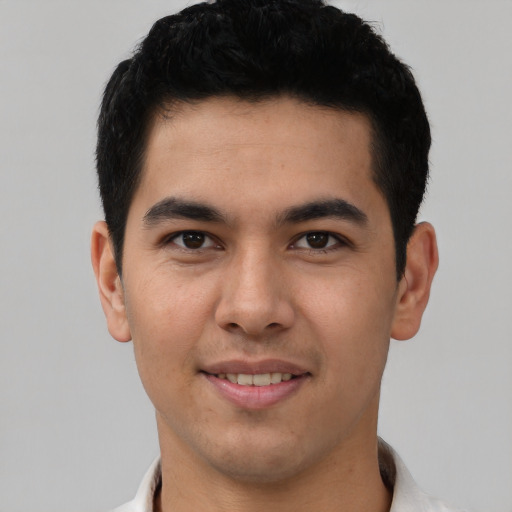 Joyful latino young-adult male with short  black hair and brown eyes