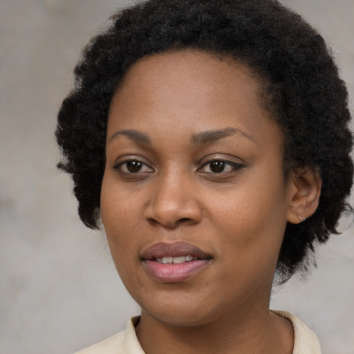 Joyful black young-adult female with short  black hair and brown eyes
