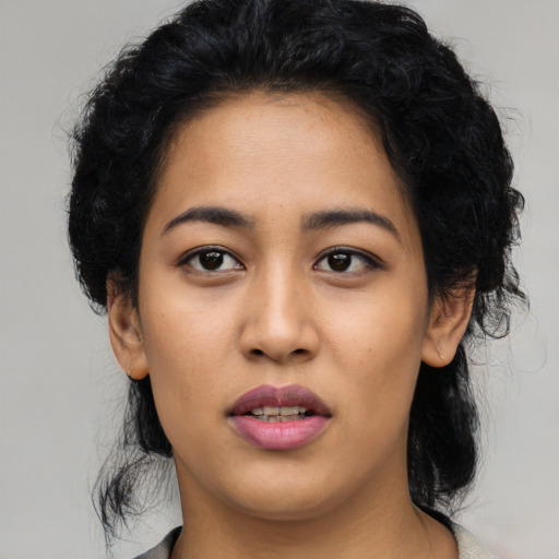 Joyful latino young-adult female with long  black hair and brown eyes