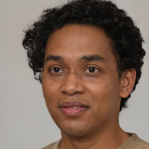 Joyful black adult male with short  black hair and brown eyes
