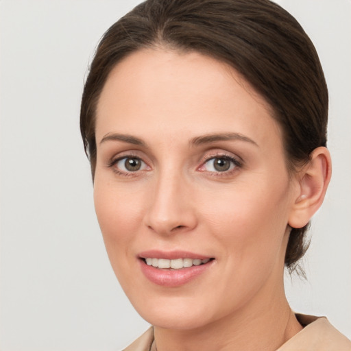 Joyful white young-adult female with medium  brown hair and grey eyes