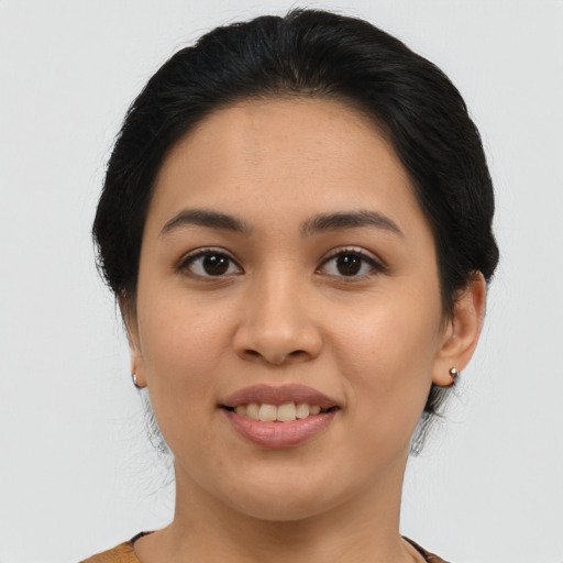 Joyful latino young-adult female with medium  brown hair and brown eyes