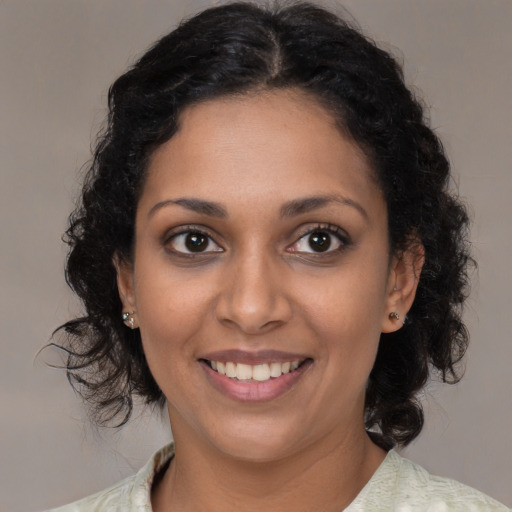Joyful black young-adult female with medium  brown hair and brown eyes