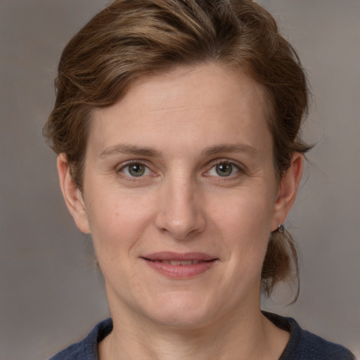 Joyful white young-adult female with medium  brown hair and grey eyes