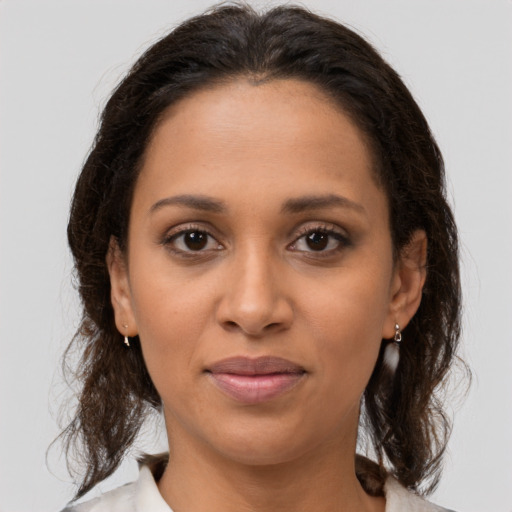 Joyful latino adult female with medium  brown hair and brown eyes