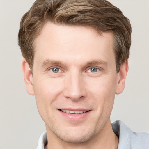 Joyful white adult male with short  brown hair and grey eyes