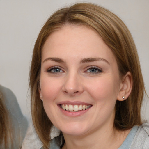 Joyful white young-adult female with medium  brown hair and blue eyes