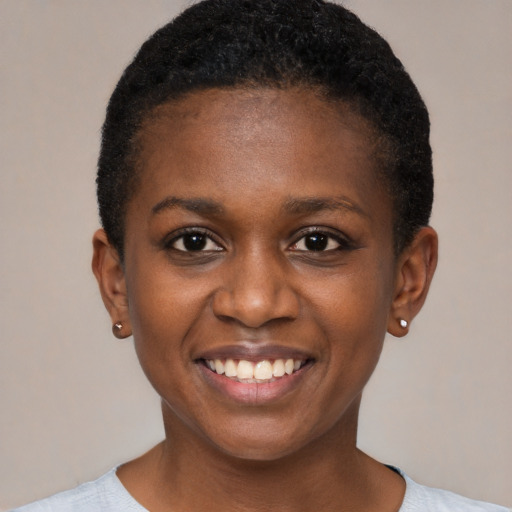 Joyful black young-adult female with short  black hair and brown eyes