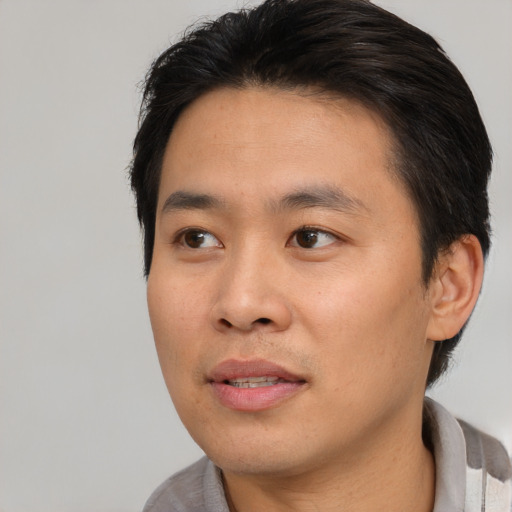 Joyful asian young-adult male with short  black hair and brown eyes