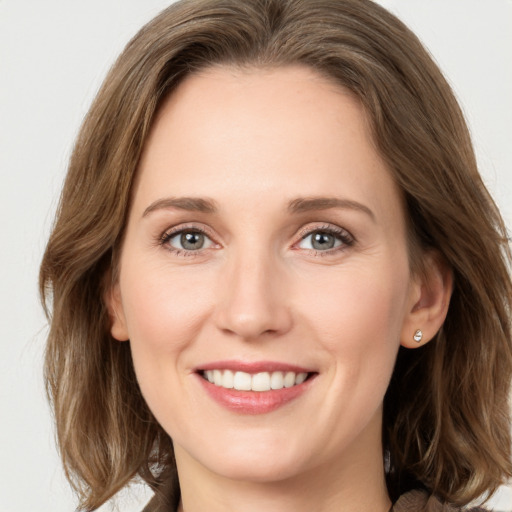 Joyful white young-adult female with medium  brown hair and green eyes