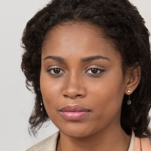 Joyful black young-adult female with long  brown hair and brown eyes