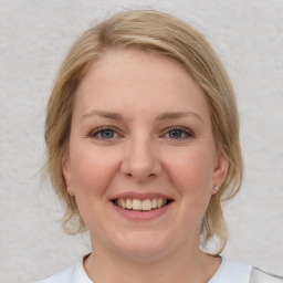 Joyful white young-adult female with medium  brown hair and blue eyes